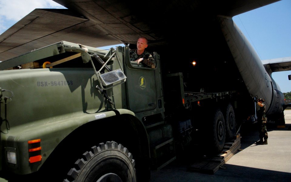 US Navy 090609-N-3674H-117 Equipment Operator 2nd Class Aaron Ambers, assigned to Naval Mobile Construction Battalion (NMCB) 74, drives a medium tactical vehicle replacement into an Air Force C-130 Hercules transport aircraft