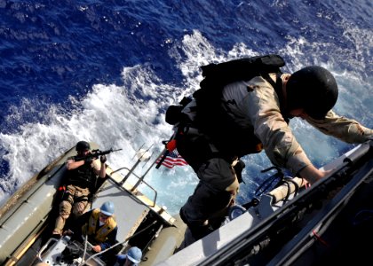 US Navy 090612-N-2638R-002 Ensign Robert Thomas, the visit, board, search and seizure officer aboard the guided-missile destroyer USS Mustin (DDG 89), climbs aboard the ship during a visit, board, search and seizure drill