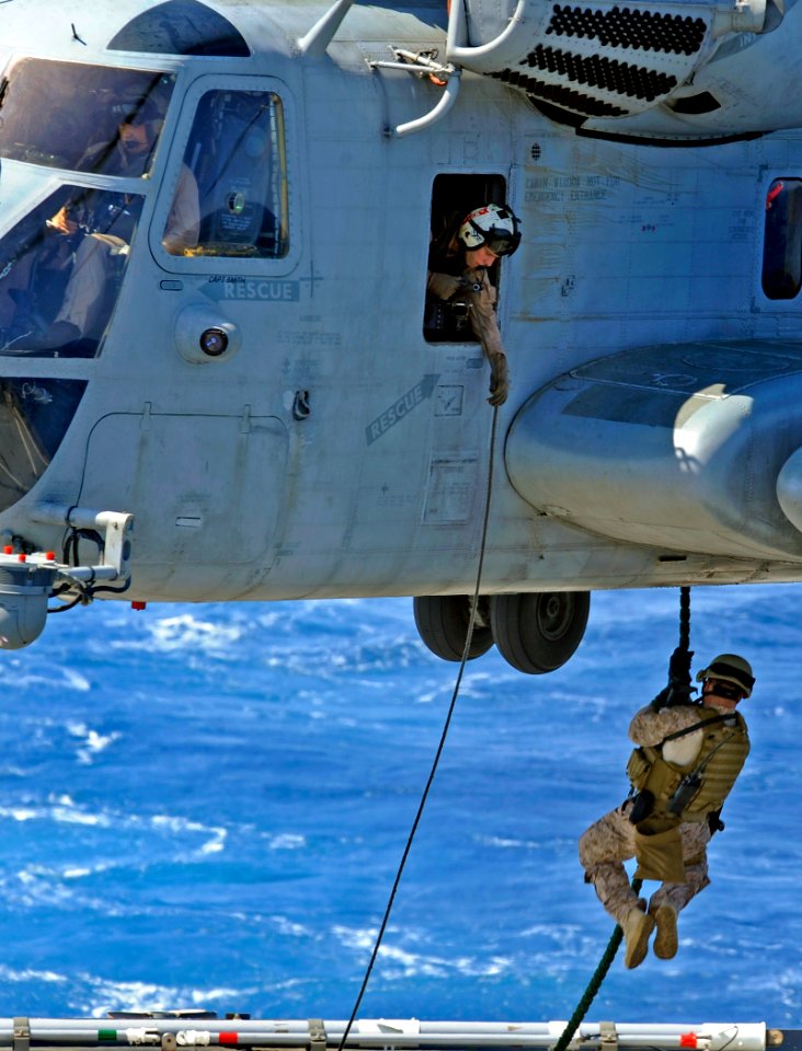 US Navy 090609-N-5345W-125 A Marine from the 22nd Marine Expeditionary Unit (MEU) Visit, Board, Search and Seizure (VBSS) team aboard USS Bataan (LHD 5) fast ropes from a CH-53 Super Stallion photo