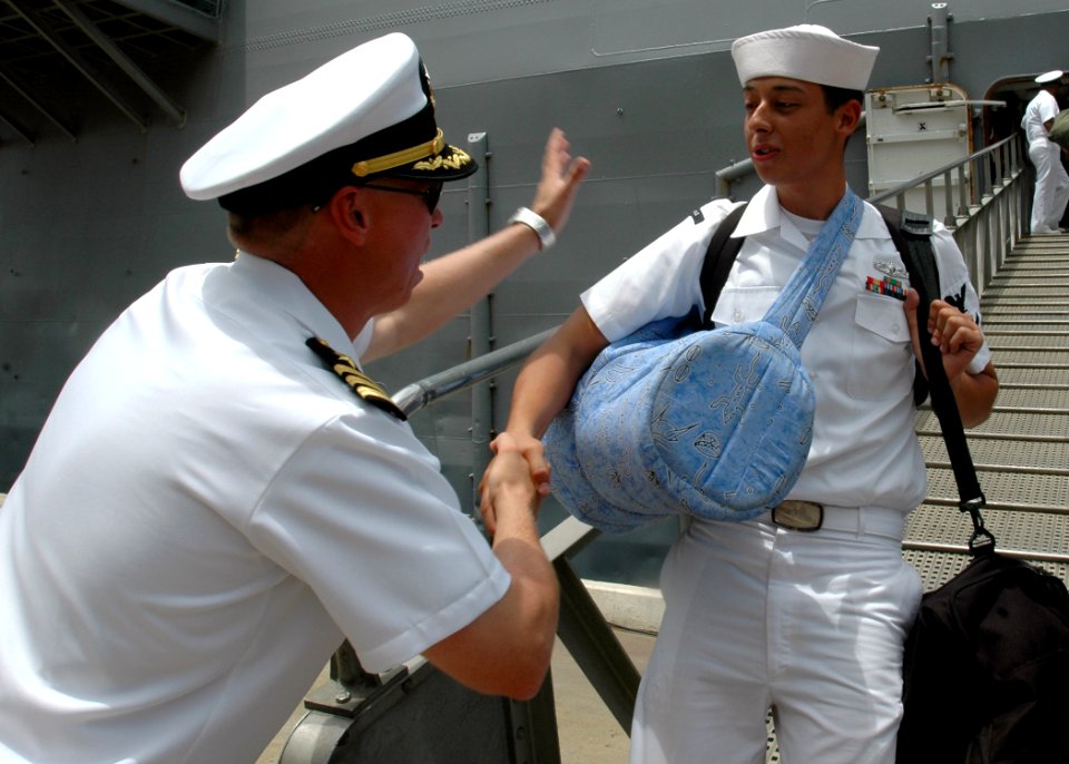 US Navy 090612-N-2456S-111 Cmdr. Brian Peterson, executive officer of the amphibious transport dock ship USS Nashville (LPD 13), congratulates Aviation Boatswain's Mate (Fuel) 3rd Class Daniel Zubiria after a five-month deploym
