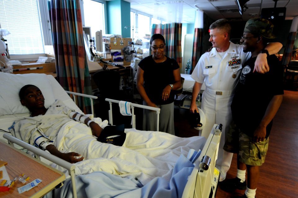 US Navy 090610-N-9818V-408 Master Chief Petty Officer of the Navy (MCPON) Rick West gives a patient a Navy ball cap and speaks to his parents