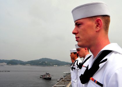 US Navy 090610-N-6233C-035 Storekeeper Seaman Kyle Buchanan mans the rails with other Sailors aboard the aircraft carrier USS George Washington (CVN 73) as the ship departs on her first summer deployment