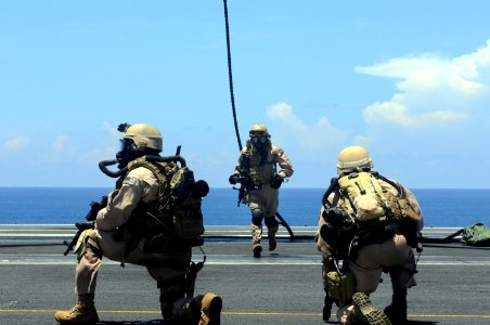 US Navy 090612-N-3659B-197 A member of Explosive Ordnance Disposal Mobile Unit (EODMU) 11, Platoon 0-2, runs across the flight deck of the aircraft carrier USS Ronald Reagan (CVN 76) during a fast-roping exercise photo