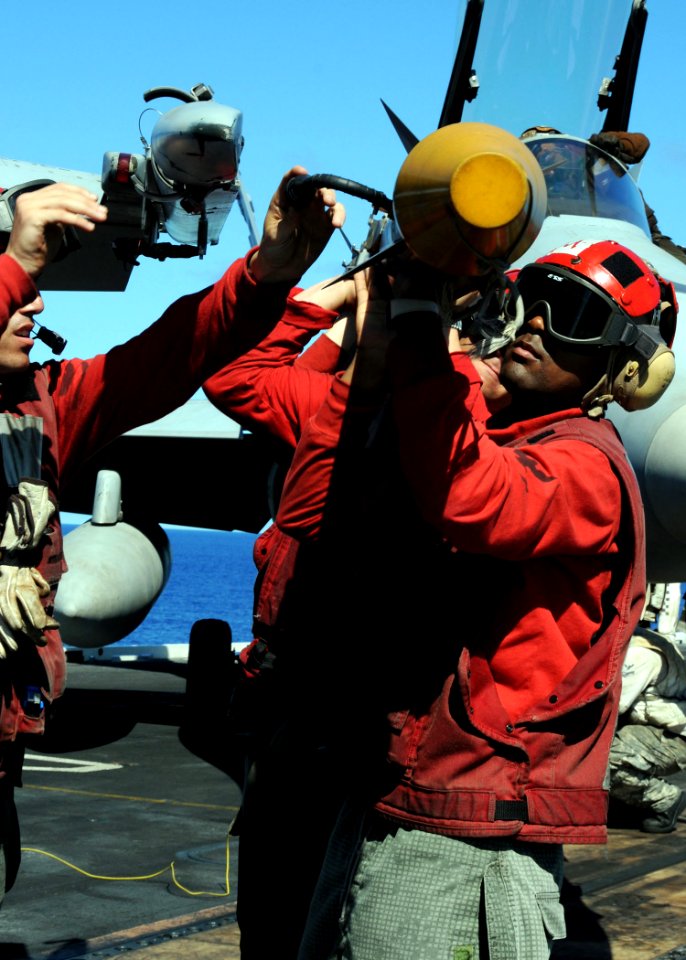 US Navy 090612-N-8534H-185 Aviation Ordnanceman 3rd Class Jamel Bell, assigned to the Golden Dragons of Strike Fighter Squadron (VFA) 192, helps offload an AIM-9 sidewinder missile