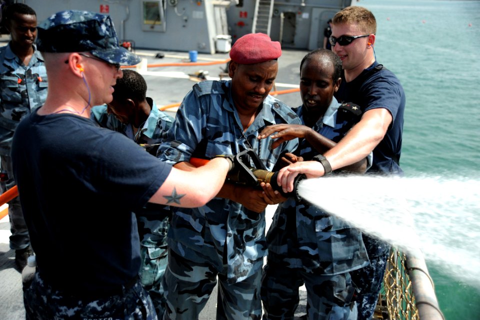 US Navy 090611-N-5242D-171 Machinery Repairman 2nd Class James Porter and Damage Controlman 1st Class James Harry train Djiboutian sailors in hose-handling techniques on the flight deck of the guided-missile destroyer USS Arlei