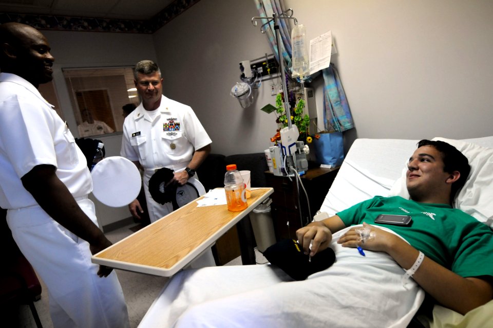US Navy 090610-N-9818V-330 A patient receives a Navy ball cap from Master Chief Petty Officer of the Navy (MCPON) Rick West and Senior Chief Petty Officer Cedric Levert