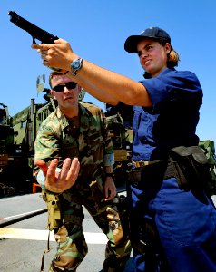 US Navy 090611-N-5345W-312 LTJG Frankie Colvin, assigned to Amphibious Squadron (PHIBRON) 2, prepares to catch Midshipman 2nd Class Sarah Van Cott's magazine while reviewing small-arms fundamentals
