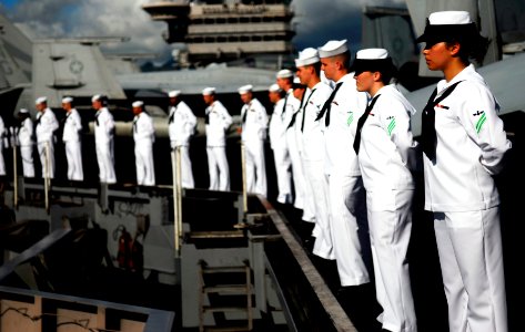 US Navy 090610-N-9928E-077 Sailors stand at parade rest while manning the rails on the flight deck aboard the aircraft carrier USS John C. Stennis (CVN 74) after rendering honors to the USS Arizona Memorial