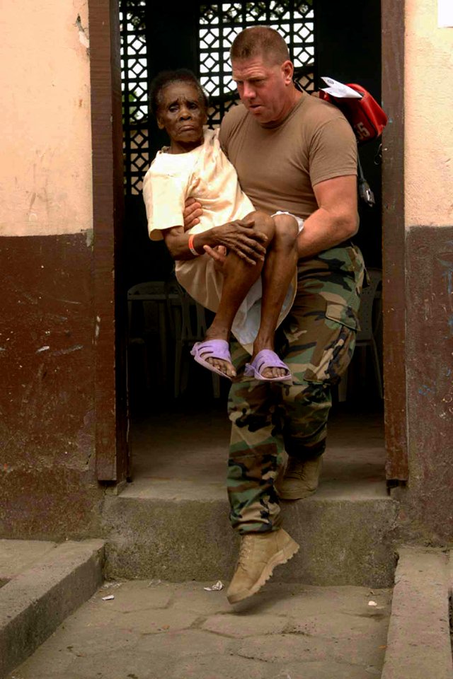 US Navy 090612-F-1333S-019 Master-At-Arms 1st Class Keith Thomas, embarked aboard the Military Sealift Command hospital ship USNS Comfort (T-AH 20), carries a patient to be seen by medical professionals