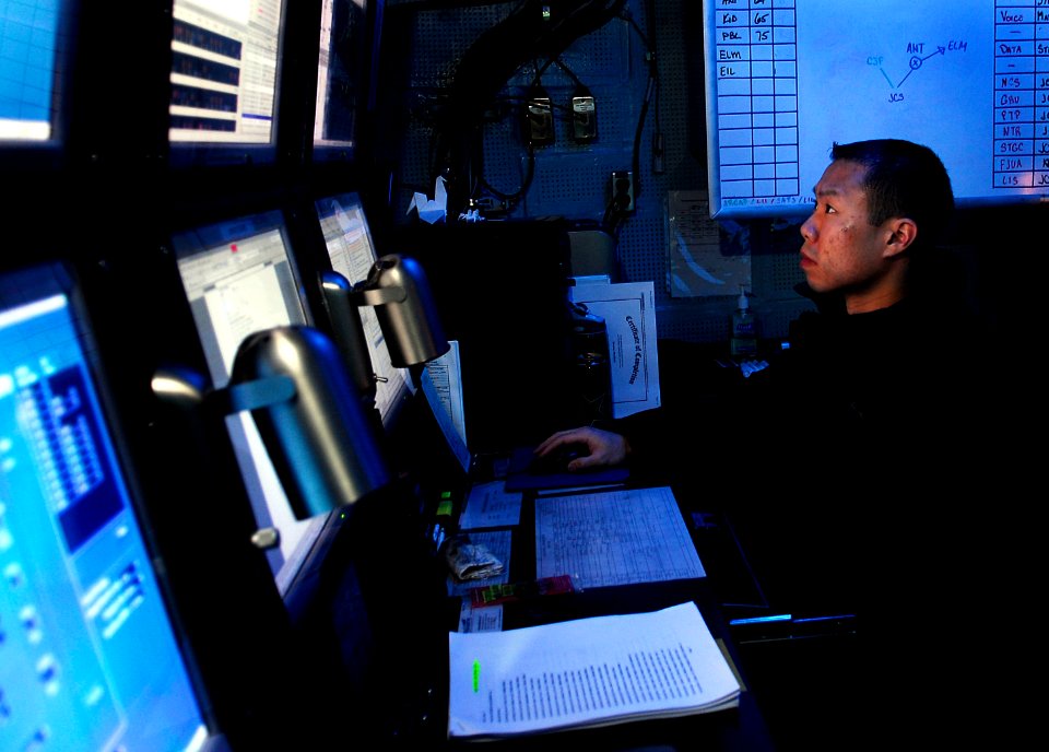 US Navy 090615-N-9928E-024 Operations Specialist 1st Class Lee Tran, from Portland, Oregon, monitors links in the tactical flag command center aboard the aircraft carrier USS John C. Stennis (CVN 74)