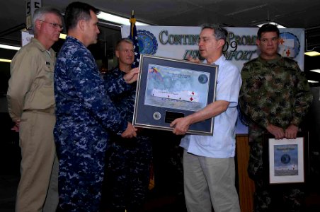US Navy 090613-F-7923S-033 Colombian President Alvaro Uribe Velez, is presented with a gift from Capt. Bob Lineberry, mission commander of Continuing Promise 2009, aboard the Military Sealift Command hospital ship USNS Comfort photo