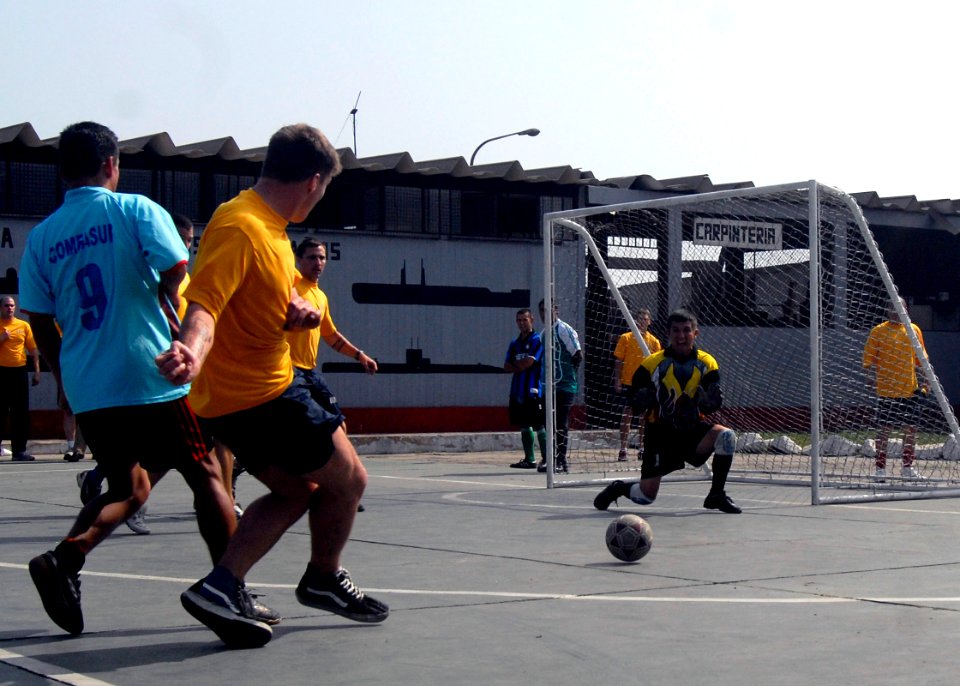 US Navy 090612-N-4879G-615 A Sailor assigned to the guided-missile frigate USS Ford (FFG 54) kicks the ball at the Peruvian Submarine Forces goal as one of their sailors drops down to block it during a multi-national soccer tou