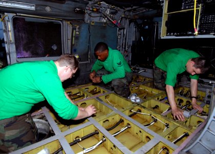 US Navy 090612-N-6720T-052 Sailors from the Chargers of Helicopter Anti-Submarine Squadron (HS) 14, apply insulating tape to the floor joists of an HH-60H Seahawk aboard USS George Washington (CVN 73)