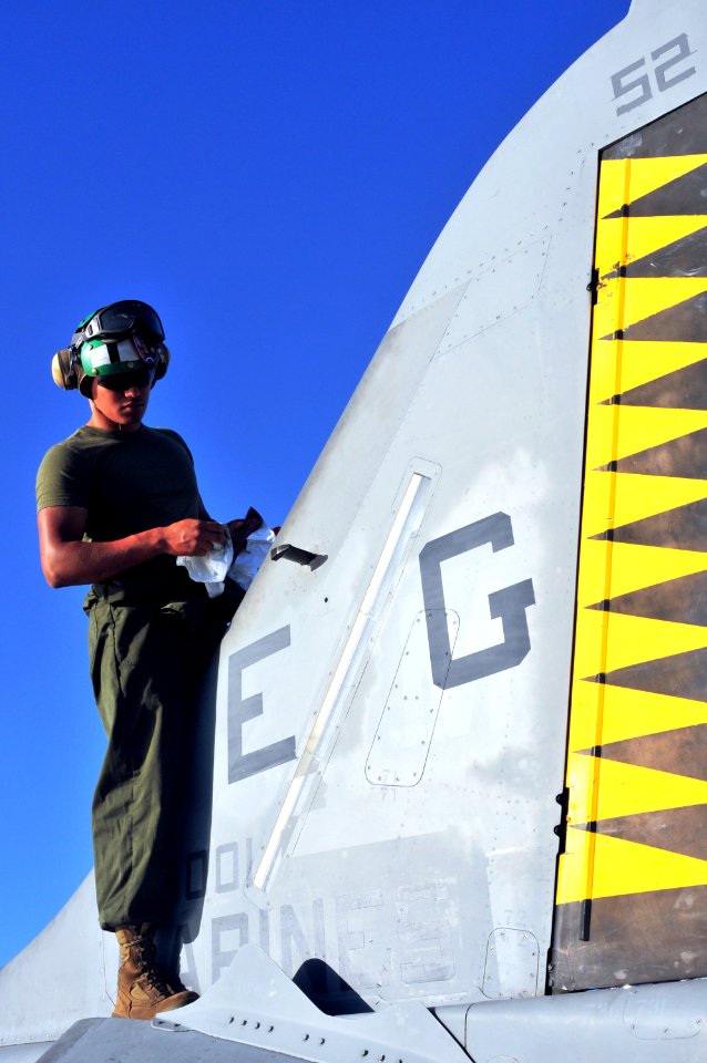 US Navy 090615-N-9740S-055 Lance Cpl. Kenneth Martinez, from Ft. Lauderdale, Fla. assigned as a plane captain to Marine Medium Tiltrotor Squadron (VMM) 263, conducts routine checks on an AV-8B Harrier