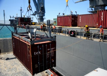 US Navy 090617-N-0577G-090 Sailors assigned to Navy Cargo Handling Battalion One (NCHB-1) work with soldiers from the Army 332nd Headquarters and Headquarters Company to move cargo from the Military Sealift Command crane ship S photo