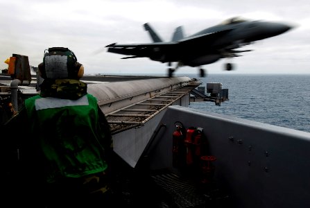 US Navy 090617-N-7780S-055 Aviation Boatswain's Mate (Equipment) Airman Manolito Recto, from Vallejo, Calif., stands flight line safety watch as an F-A-18E Super Hornet launches from the aircraft carrier USS John C. Stennis (CV
