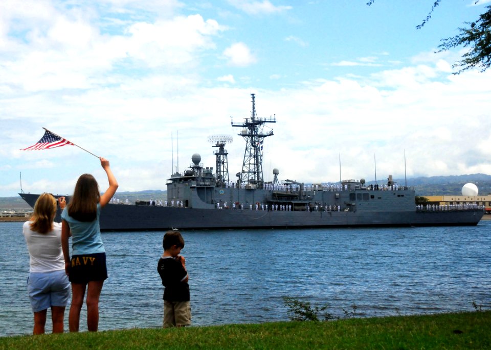 US Navy 090615-N-8539M-090 Family members of Sailors assigned to the Oliver Hazard Perry-class guided-missile frigate USS Crommelin (FFG 37) watch as the ship departs Pearl Harbor
