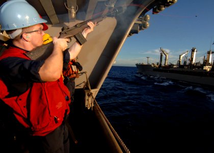 US Navy 090613-N-7282P-087 Gunner's Mate 3rd Class Jessup Taylor uses an M-14 rifle to shoot a receiving line from the aircraft carrier USS George Washington (CVN 73) to the Military Sealift Command fleet replenishment oiler US