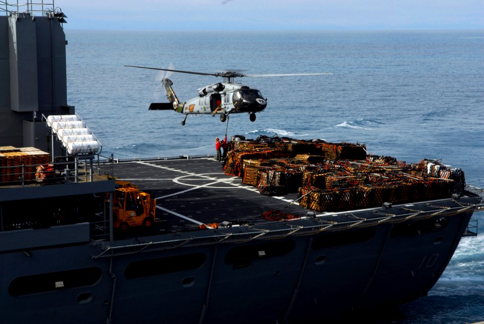 US Navy 090616-N-2475A-106 An MH-60S Sea Hawk from the Eightballers of Helicopter Sea Combat Squadron (HSC) 8 hovers over the flight deck of USNS Bridge (T-AOE 10) to pick up pallets of supplies for transfer