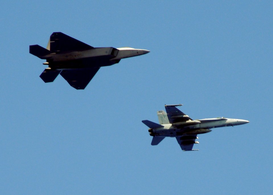 US Navy 090617-N-1644H-029 An F-A-18C Hornet from the Golden Dragons of Strike Fighter Squadron (VFA) 192 flies with an Air Force F-22 Raptor from the 525th Fighter Squadron