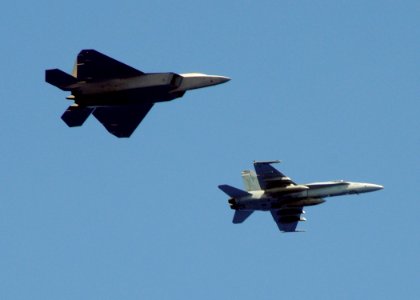 US Navy 090617-N-1644H-029 An F-A-18C Hornet from the Golden Dragons of Strike Fighter Squadron (VFA) 192 flies with an Air Force F-22 Raptor from the 525th Fighter Squadron
