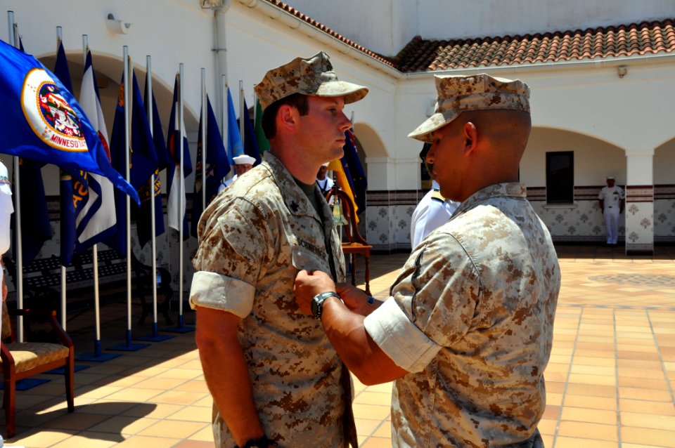 US Navy 090619-N-1825E-346 Marine Staff Sgt. Jose Lucero, Company Staff Sgt., Fleet Anti-Terrorism Security Team Europe Detachment Rota, pins the Bronze Star Medal with Valor to Hospital Corpsmen 3rd Class Stephen Schneider