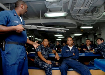 US Navy 090617-A-1839I-051 Fire Controlman 1st Class Patrick Fairley conducts a firearms training session on the use of a shotgun aboard the amphibious dock landing ship USS Oak Hill (LSD 51)