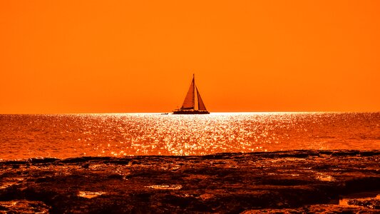 Catamaran rocky coast orange photo