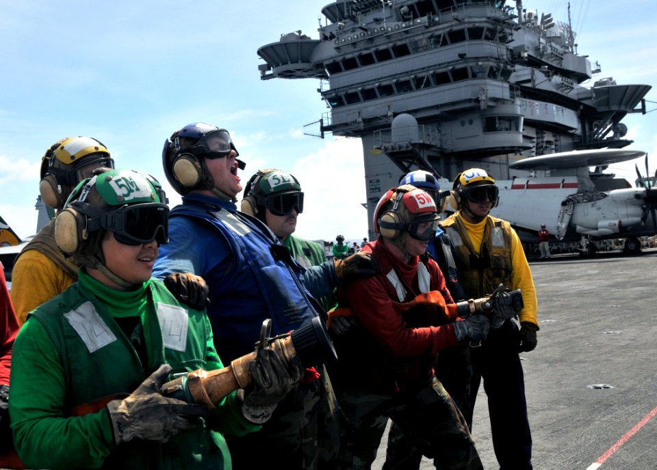 US Navy 090619-N-8534H-108 Aviation Boatswain's Mate (Handling) Airmen Apprentice Steven Oliver leads his team during a simulated aircraft fire drill