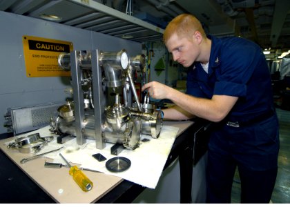 US Navy 090622-N-6720T-060 Aviation Electronics Technician 3rd Class Adrian Huth, assigned to the aviation intermediate maintenance department, performs maintenance on a high voltage load testing unit aboard the aircraft carrie