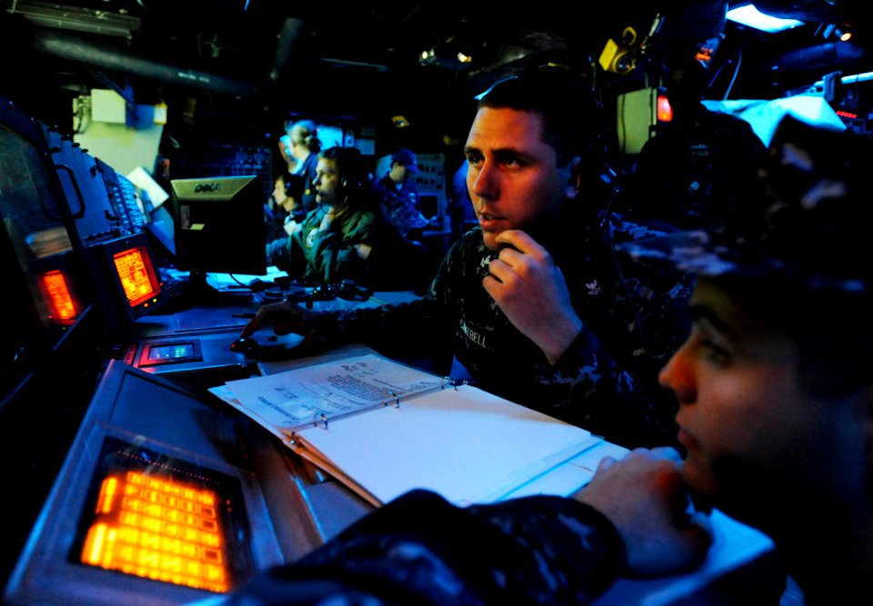US Navy 090619-N-5345W-076 Operations Specialist 2nd Class Timothy Cantrell monitors a status board while operating as sensor supervisor in the combat information center aboard the amphibious dock landing ship USS Fort McHenry