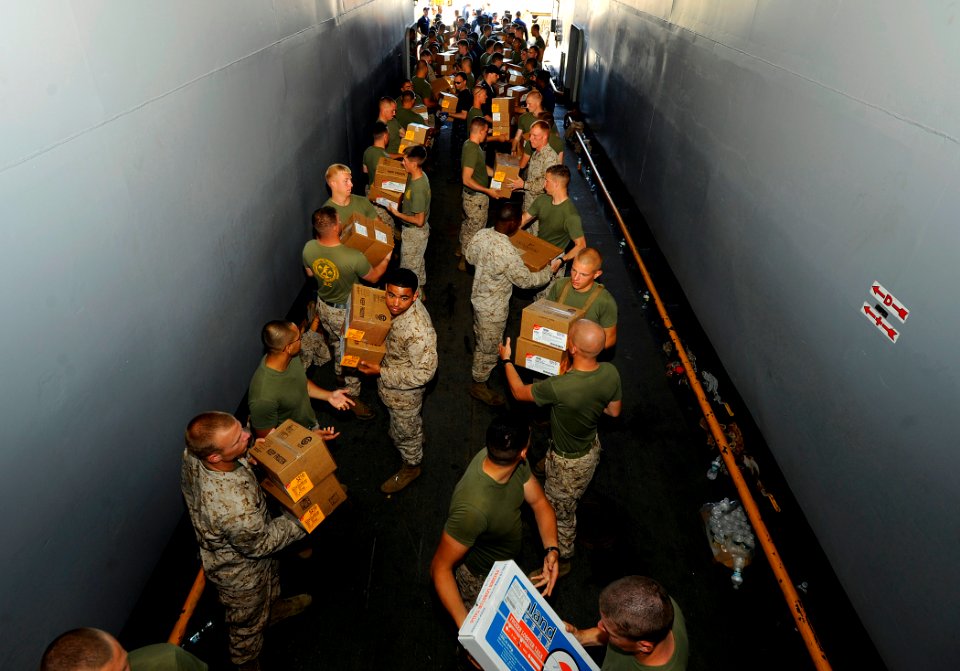 US Navy 090617-N-5345W-089 Sailors and Marines aboard the amphibious dock landing ship USS Fort McHenry (LSD 43) move boxes of supplies through the ship's truck tunnel to below decks while onloading stores during a port visit