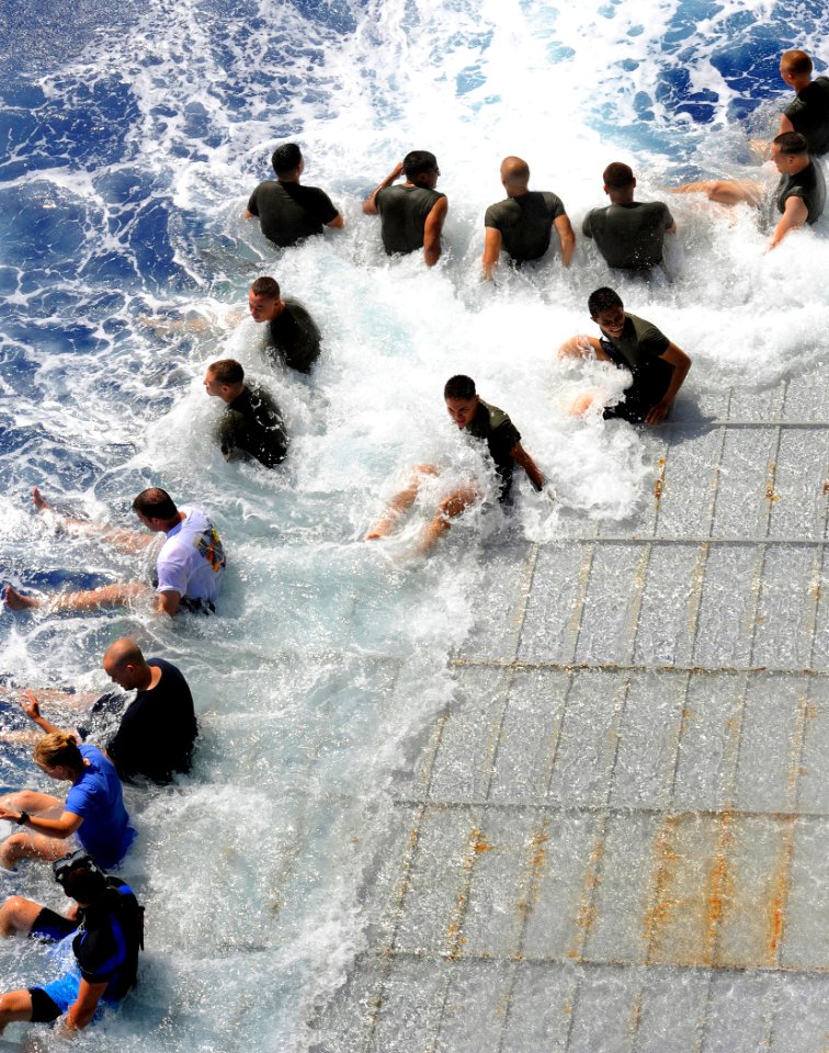 US Navy 090621-N-5345W-236 Sailors and Marines let the waves wash up over them as they sit on the stern gate of USS Fort McHenry (LSD 43)