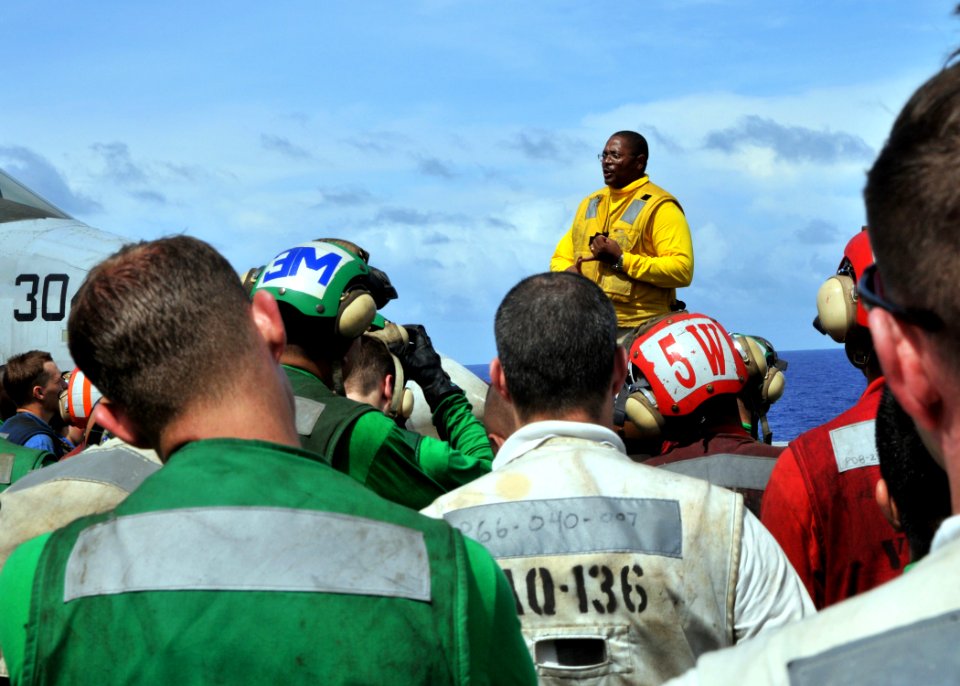 US Navy 090619-N-8534H-129 Chief Warrant Officer James Edwards, air department training team coordinator aboard USS George Washington (CVN 73), praises Sailors for hard work and proper execution during drills