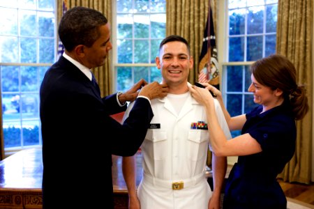 US Navy 090623-N-0000G-001 U.S. President Barack Obama puts on Navy Ensign shoulder boards during Ghanbari's commissioning ceremony in the White House Oval Office photo