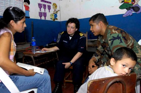 US Navy 090622-F-7923S-009 Medical personnel explain how to treat a sinus infection with water and soap to an El Salvadorian woman