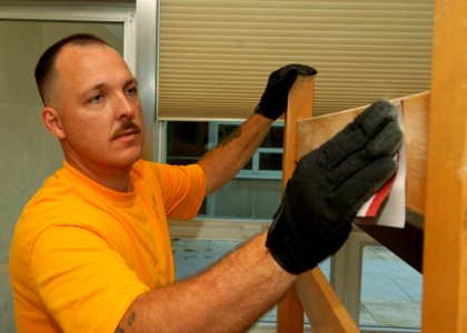 US Navy 090619-N-6125G-042 enior Chief Postal Clerk Chad McCann, assigned to USS George H.W. Bush (CVN 77), sands down a bunk bed