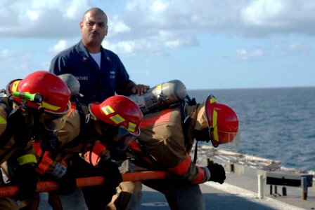 US Navy 090620-N-0924R-002 Damage Controlman 1st Class Miguel Vazquez instructs a hose-handling team during damage control training