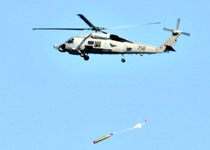 US Navy 090622-N-2638R-002 An SH-60B Sea Hawk helicopter assigned to the Warlords of Helicopter Anti-Submarine Squadron Light (HSL) 51 drops a MK-46 recoverable exercise torpedo photo