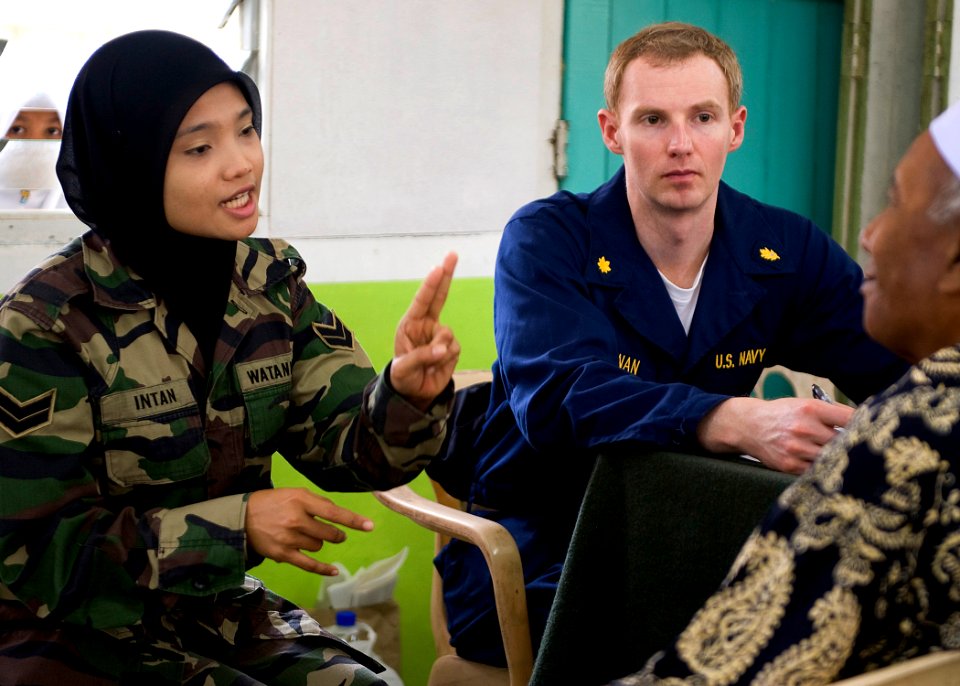 US Navy 090624-N-1722M-401 U.S. Navy doctor Lt. Cmdr. Scott Bannan and Malaysian Army Cpl. Intan Badri screen a patient during a Cooperation Afloat Readiness and Training (CARAT) Malaysia 2009 medical civil action project