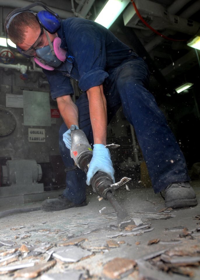 US Navy 090623-N-1229B-009 Interior Communications Specialist 3rd class Shawn Davidson, from Las Cruces, N.M., removes the deck surface during a berthing space restoration aboard the aircraft carrier USS Abraham Lincoln (CVN 7