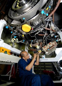 US Navy 090622-N-6720T-015 Aviation Machinist's Mate 1st Class James Gregorio, assigned to the jet engine shop in the aviation intermediate maintenance department, installs a wiring harness on an F-A-18E Super Hornet engine
