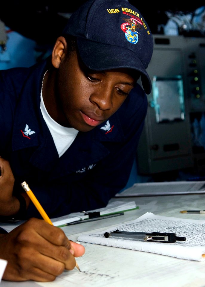 US Navy 090625-N-5253W-003 Quartermaster 3rd Class Jonathan Hall, from Capital Heights, Md. assigned to the amphibious assault ship USS Essex (LHD 2), plots a reading on a navigation chart in the ship's pilot house