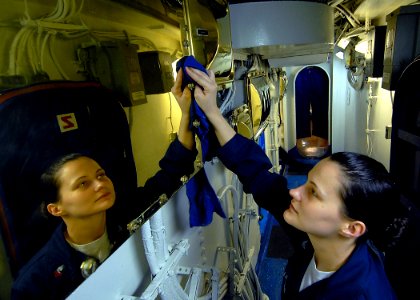 US Navy 090623-N-6720T-033 Operations Specialist 2nd Class Kimberly Buchanan polishes bright work during cleaning stations aboard the aircraft carrier USS George Washington (CVN 73)