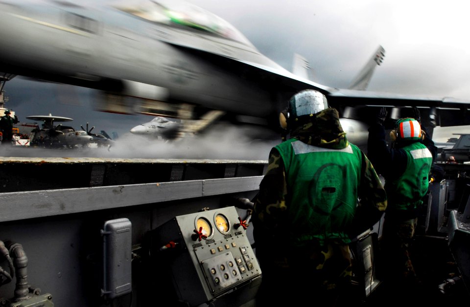 US Navy 090623-N-7780S-120 Sailors watch an F-A-18F Super Hornet assigned to the Black Knights of Strike Fighter Squadron (VFA) 154 launch from the aircraft carrier USS John C. Stennis (CVN 74)