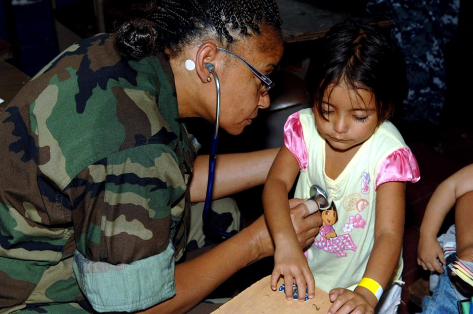 US Navy 090626-F-1333S-022 Lt. Cmdr. Yolanda Mitchell-Lee, embarked aboard the Military Sealift Command hospital ship USNS Comfort (T-AH 20), examines a child during a Continuing Promise 2009 medical community service project