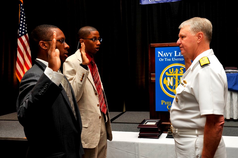 US Navy 090624-N-8273J-117 Chief of Naval Operations (CNO) Adm. Gary Roughead, administers the oath of enlistment to Chris Dugan and Chris Meade during the 2009 annual Navy League Dinner in Philadelphia, Penn