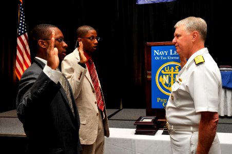 US Navy 090624-N-8273J-117 Chief of Naval Operations (CNO) Adm. Gary Roughead, administers the oath of enlistment to Chris Dugan and Chris Meade during the 2009 annual Navy League Dinner in Philadelphia, Penn