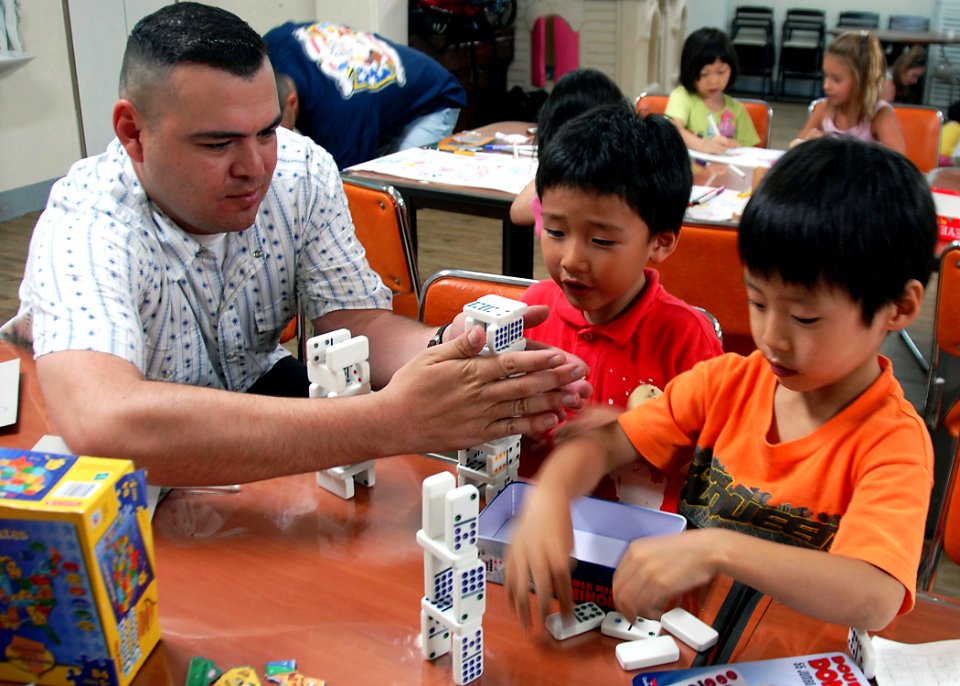 US Navy 090624-N-9573A-021 Equipment Operator 1st Class Mario Gonzalez, from Los Angeles, stacks dominos with children from the Hye Sim Won Orphanage in Seoul