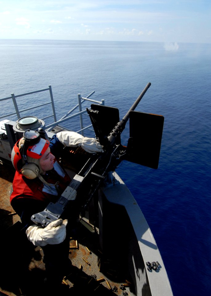 US Navy 090623-N-6720T-019 Aviation Ordnanceman 2nd Class Daniel Miller, assigned to the weapons department, G-3 division, of the aircraft carrier USS George Washington (CVN 73), loads a .50 caliber machine gun during a live-fi